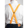 Dettaglio incrocio a X Bretelle elastiche colore arancione indossate con camicia bianca